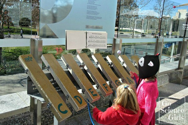 Kids playing the lithophone (stone musical instrument) outside Questacon
