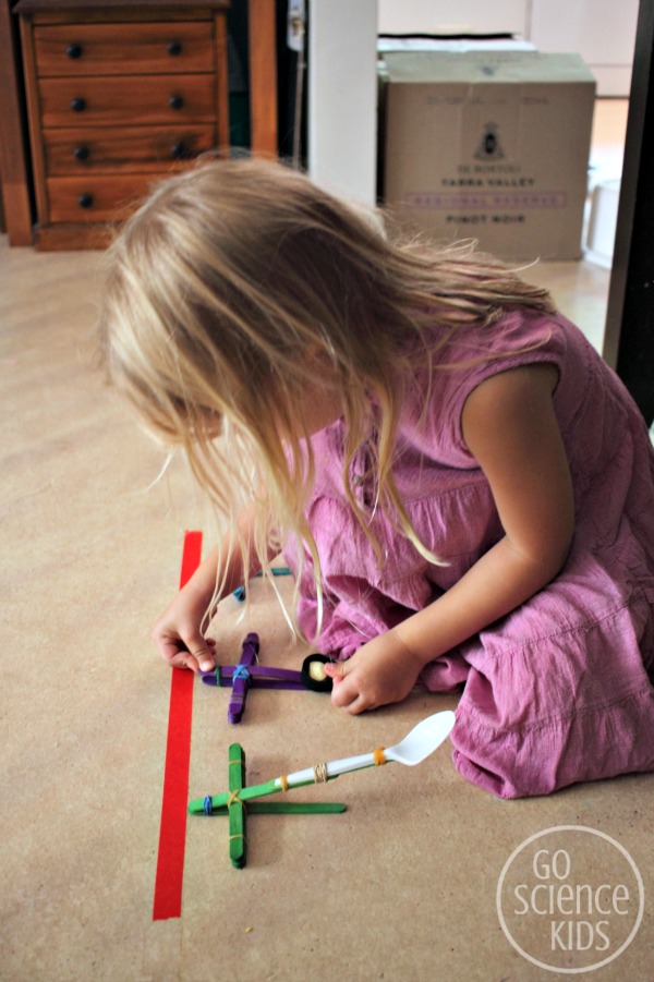 Preparing to launch her projectile with her DIY craft stick catapult